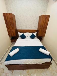 a bedroom with a bed with blue and white pillows at Hotel DVL INN- Near Jalmahal Jaipur in Jaipur