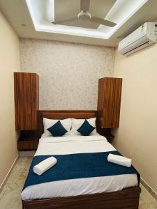 a bedroom with a bed with blue and white pillows at Hotel DVL INN- Near Jalmahal Jaipur in Jaipur
