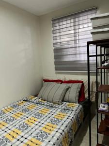 a small bedroom with a bed with a window at Log Horizon by The Guild Oasis Transient House in Rosario