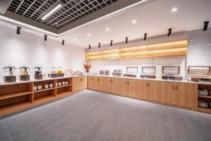 a large kitchen with wooden cabinets and counters at Zhangjiajie Homeinn Hotel- New Hotel,Free Breakfast, Free Self-Service Laundry & Drying, Attraction Tickets Serivce in advance,Toursim info in Zhangjiajie +32 photos