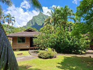 a house with a mountain in the background at Eco Lodge Village Temanoha in Paopao