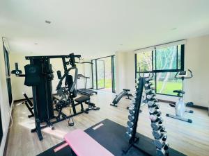 a gym with treadmills and machines in a room at Harmony Resort Hotel in Chiang Mai