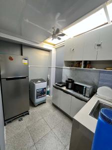 a kitchen with a refrigerator and a microwave at Log Horizon by The Guild Oasis Transient House in Rosario