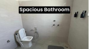a bathroom with a toilet and a sign that readsynchronous bathroom at The Velvet Nest - Gurgaon - Luxurious Single Bedroom Private Villa with Garden in Gurgaon