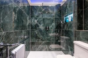 a bathroom with a green tiled shower with a toilet at The Gifford in Edinburgh +116 photos