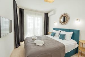a bedroom with a large bed with blue accents at Azure Bay in Igalo +20 photos