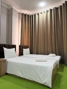 a bedroom with two beds in front of a curtain at Chinor Garden Hotel - Free Airport Pick-up Yandex Go in Tashkent