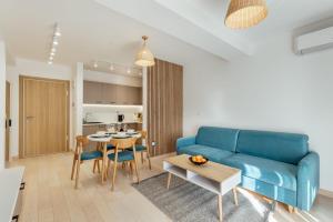a living room with a blue couch and a table at Azure Bay in Igalo
