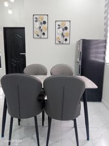 a table and four chairs in a room at Dhila Homestay Jalan Pasir Mas Rantau Panjang in Pasir Mas