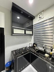 a kitchen with a black counter top in a kitchen at Dhila Homestay Jalan Pasir Mas Rantau Panjang in Pasir Mas