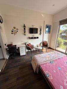 a bedroom with a bed and a desk and chairs at AeroNest Luxe in Zirakpur