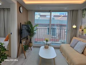 ein Wohnzimmer mit Sofa und Balkon in der Unterkunft Gate 303 in Seoul