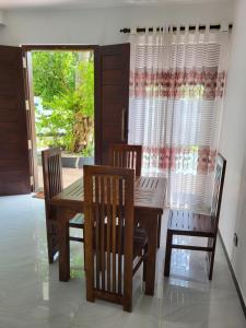 a dining room with a table and chairs and a window at Villa Olive in Hikkaduwa