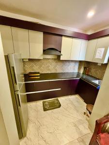 a kitchen with white cabinets and a tile floor at Mokshika Homes at Rishikesh in Birbhaddar