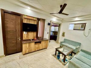 a living room with a couch and a flat screen tv at Mokshika Homes at Rishikesh in Birbhaddar