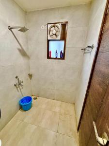 a bathroom with a window and a blue bucket at Mokshika Homes at Rishikesh in Birbhaddar +17 photos