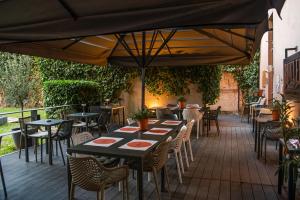 a patio with tables and chairs and an umbrella at Hotel Sliško in Zagreb