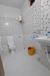 a white bathroom with a toilet and a sink at Lakshmi Divya Guest house in Pedda Ahobilam
