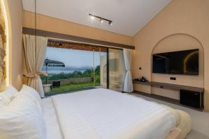 a bedroom with a large bed and a large window at Mount Valley Inn in Kubupenlokan