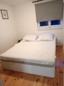 a white bed in a room with a window at Chata Borecké skály in Ktová