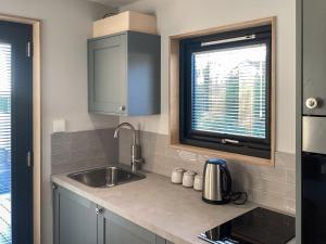 a kitchen with a sink and a window at Wee Shore Walk in Balintore +6 photos