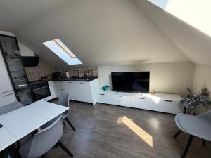 a kitchen with white cabinets and a large screen tv at Luxury flat 2 in Pleven