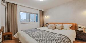 a bedroom with a large bed and a window at 上海NICE民宿 Shanghai NICE B&B ZFC in Shanghai