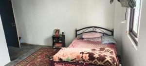 a small bedroom with a bed and a rug at Mamta's Homestay in Aritar