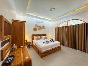 a bedroom with a bed and a table and a tv at The Lauk private in Gili Islands