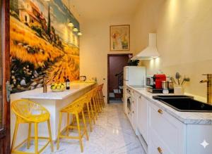 a kitchen with a sink and a counter with chairs at Villa Leonardo House Pisa Secret Garden in Pisa +28 photos