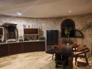a kitchen with a wooden table and a kitchen with a refrigerator at Casa caracol Macario in Macario Gomez