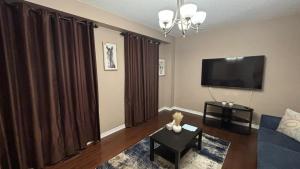 a living room with a couch and a flat screen tv at Halton Hills Haven in Milton