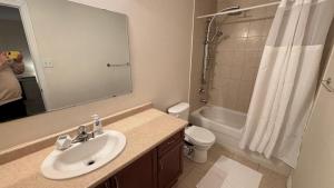 a bathroom with a sink and a toilet and a mirror at Halton Hills Haven in Milton