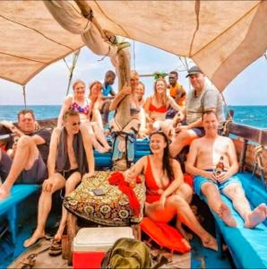 a group of people sitting on the back of a boat at Wasini dolphin adventure in Shimoni