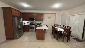 a kitchen with wooden cabinets and a table with chairs at Halton Hills Haven in Milton +47 photos