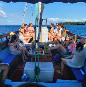 a group of people sitting on a boat on the water at Wasini dolphin adventure in Shimoni