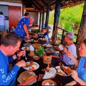 a group of people sitting at a table eating food at Wasini dolphin adventure in Shimoni