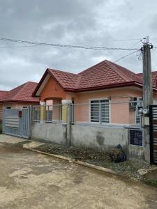 a pink house with a fence in front of it at Casa Solana at Malaybalay VCDU Phase 3 B4 L22 in Malaybalay