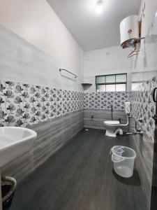 a bathroom with a sink and a toilet at Naadi Grand Inn in Thanjāvūr +63 photos