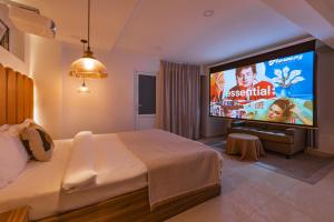 a bedroom with a bed and a large screen television at GreenMeadow Central Boutique in Da Lat