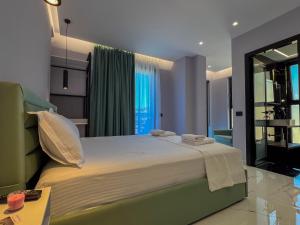 a bedroom with a large bed with towels on it at Saranda's Crown in Sarandë