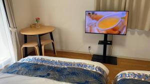 a bedroom with a bed and a flat screen tv at 星の宿大阪城 in Osaka