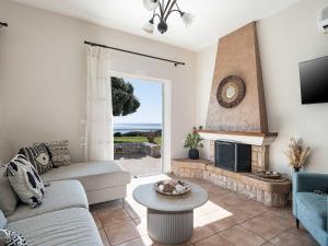 a living room with a couch and a fireplace at Casa Horizon in Palaiochora