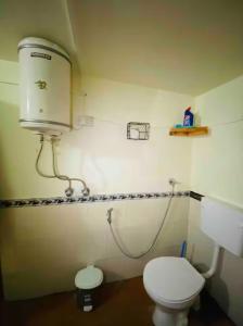 a bathroom with a toilet and a water tank at Peak & Pine cottage in Almora +23 photos