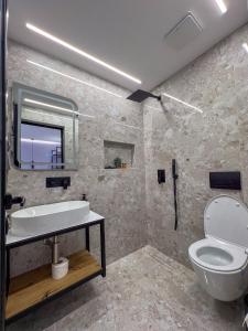 a bathroom with a white toilet and a sink at Saranda's Crown in Sarandë +61 photos