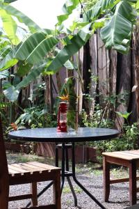 a table with a vase on it next to two benches at Hostel, Café & Garden Travelers in Santiago