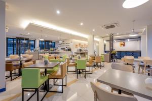 ein Restaurant mit Tischen und Stühlen und einer Cafeteria in der Unterkunft De Hug Hotel & Residence in Chiang Rai