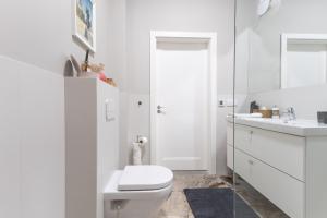 a white bathroom with a toilet and a sink at Baltivia Haus II in Gdynia +10 photos