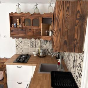 a kitchen with a sink and a wooden counter top at Árpád nyaralóház in Sarud