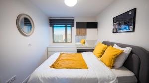 a bedroom with a large bed with yellow pillows at Sky One La Defense in Courbevoie